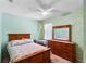 Green bedroom with a bed, dresser, and nightstand set illuminated by natural light at 1868 Rachels Ridge Loop # L, Ocoee, FL 34761