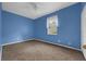 This bedroom features blue walls, neutral carpet, and a ceiling fan at 1868 Rachels Ridge Loop # L, Ocoee, FL 34761