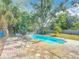 Backyard showcasing the in-ground pool with tropical foliage at 1901 Rose Blvd, Orlando, FL 32839