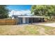 This backyard features a covered patio area, wood fence, and is surrounded by mature trees, offering ample privacy at 1901 Rose Blvd, Orlando, FL 32839