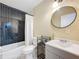 Stylish bathroom with subway-tiled shower and a modern round mirror at 1901 Rose Blvd, Orlando, FL 32839