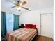 Cozy bedroom with a ceiling fan, hardwood floors, natural light and red pillows at 1901 Rose Blvd, Orlando, FL 32839