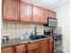 Well-lit kitchen featuring warm wood cabinetry, granite countertops, and stainless steel appliances at 1901 Rose Blvd, Orlando, FL 32839