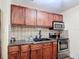 Well-lit kitchen featuring granite countertops, stainless appliances, and dark wood cabinets at 1901 Rose Blvd, Orlando, FL 32839