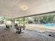 Covered patio with tables overlooking the backyard and pool at 1901 Rose Blvd, Orlando, FL 32839