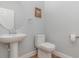 Modern powder room features pedestal sink, round mirror, and neutral paint at 2167 Pearl Cider St, Orlando, FL 32824