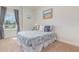 Cozy bedroom featuring patterned bedding, soft pillows, a side table lamp and a large window at 2167 Pearl Cider St, Orlando, FL 32824