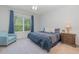 Cozy bedroom with plush carpet, stylish bedding, and large window overlooking greenery at 2167 Pearl Cider St, Orlando, FL 32824