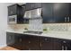Modern kitchen boasts sleek black cabinetry, stainless steel appliances, and stylish mosaic backsplash at 2167 Pearl Cider St, Orlando, FL 32824