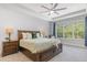 Serene main bedroom with a large window, neutral tones, tray ceiling, and an ensuite bathroom at 2167 Pearl Cider St, Orlando, FL 32824
