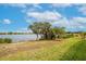 Backyard view of a lake with lush green grass and trees with hanging moss and community homes at 2173 Lake Side Ave, Davenport, FL 33837