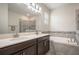 Well-lit bathroom featuring double sinks, a soaking tub, and a separate shower at 2173 Lake Side Ave, Davenport, FL 33837