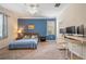 Well-lit bedroom with blue accent wall, large window and a desk workstation at 2173 Lake Side Ave, Davenport, FL 33837
