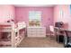Pink bedroom with a bunk bed, large window, and a desk at 2173 Lake Side Ave, Davenport, FL 33837