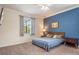 Comfortable bedroom with neutral carpet, a queen bed, and a blue accent wall at 2173 Lake Side Ave, Davenport, FL 33837