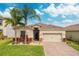 Beautiful single-Gathering home showcasing a tile roof, mature palm trees and a paver driveway at 2173 Lake Side Ave, Davenport, FL 33837