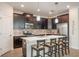 Modern kitchen with dark cabinetry, stainless steel appliances, a tile backsplash, and a breakfast bar at 2173 Lake Side Ave, Davenport, FL 33837