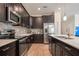 Well-equipped kitchen featuring stainless steel appliances, dark wood cabinets, and sleek countertops at 2173 Lake Side Ave, Davenport, FL 33837