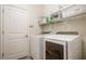 Functional laundry room includes a full size washer and dryer, storage shelves, and a door at 2173 Lake Side Ave, Davenport, FL 33837