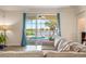 Living room with tan sofas and open sliding glass doors to views of the screened-in pool and lake at 2173 Lake Side Ave, Davenport, FL 33837