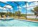 Relaxing screened-in pool and spa overlooking a serene lake at 2173 Lake Side Ave, Davenport, FL 33837