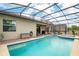 Relaxing backyard oasis with a screened-in pool, spa, brick paver patio and comfortable seating at 2173 Lake Side Ave, Davenport, FL 33837
