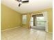 Bright bedroom with tile floors, large windows, sliding doors to a balcony, and a ceiling fan at 2214 Metropolitan Way # 1032, Orlando, FL 32839