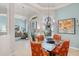 Bright dining room with a glass table, shell-themed chairs, and decorative lighting at 224 Bluestone Pl, Casselberry, FL 32707