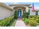 Close up view of a home's arched entryway with a bright blue front door and landscaped walkway at 224 Bluestone Pl, Casselberry, FL 32707