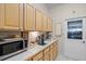 Bright laundry area featuring modern appliances, ample counter space, and natural wood cabinetry at 224 Bluestone Pl, Casselberry, FL 32707