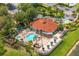 Aerial view of a community pool with pool house, hot tub, lounge seating, palm trees, and a bar at 2769 Lido Key Dr, Kissimmee, FL 34747