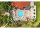 Aerial view of community pool, hot tub, and lounge seating surrounded by mature trees and landscaping at 2769 Lido Key Dr, Kissimmee, FL 34747