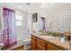 Bathroom with granite vanity top, wood cabinetry, and purple shower curtain at 2769 Lido Key Dr, Kissimmee, FL 34747