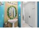 Half bath with pedestal sink, decorative mirror, and adjacent door at 2769 Lido Key Dr, Kissimmee, FL 34747