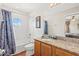 Bright bathroom featuring a granite vanity top, a round window, and a shower-tub combo at 2769 Lido Key Dr, Kissimmee, FL 34747