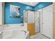 Bathroom featuring a garden tub, glass-enclosed shower, and vibrant blue walls at 2769 Lido Key Dr, Kissimmee, FL 34747