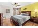Bedroom with wood floors, ceiling fan, large bed, and colorful accent wall at 2769 Lido Key Dr, Kissimmee, FL 34747