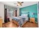 Cozy bedroom with wood floors, ceiling fan, stylish bedding, and an accent wall at 2769 Lido Key Dr, Kissimmee, FL 34747
