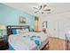 Bright bedroom features blue accent wall, hardwood floors, and ensuite bathroom at 2769 Lido Key Dr, Kissimmee, FL 34747