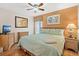 Bedroom with wood floors, ceiling fan, queen bed, and an orange accent wall at 2769 Lido Key Dr, Kissimmee, FL 34747