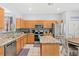 This kitchen features a central island, stainless appliances, granite countertops, and light wood cabinets at 2769 Lido Key Dr, Kissimmee, FL 34747