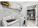 Bright laundry room featuring a modern washer and dryer, shelving, and an open doorway at 2769 Lido Key Dr, Kissimmee, FL 34747
