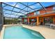 A screened pool with hot tub, lounge chairs, covered patio and an outdoor tv and fan at 2769 Lido Key Dr, Kissimmee, FL 34747