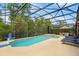 A screened in pool with a basketball hoop and a lounge chairs alongside an umbrella covered table set at 2769 Lido Key Dr, Kissimmee, FL 34747