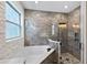 Bathroom featuring soaking tub with stone accents, glass shower and stylish tile work at 3138 Twin Shore Ln, Orlando, FL 32824