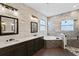 Modern bathroom with double vanity, soaking tub, decorative tile, and glass-enclosed shower at 3138 Twin Shore Ln, Orlando, FL 32824