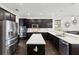 Modern kitchen with stainless steel appliances, dark cabinets, and a center island with white countertops at 3138 Twin Shore Ln, Orlando, FL 32824