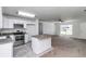 Open-concept kitchen with island, stainless steel appliances, flowing into the carpeted living area at 3914 Sw 161St Loop, Ocala, FL 34473