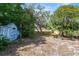 A spacious backyard with mature trees and a storage shed at 4070 Mcneil Rd, Apopka, FL 32703