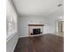 Sunlit living room with hardwood floors, neutral walls, and a brick fireplace provides a warm, inviting space at 4070 Mcneil Rd, Apopka, FL 32703